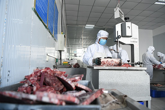 扎鲁特旗玛拉沁艾力食品有限公司工人正在切割牛排（陈立庚 摄）
