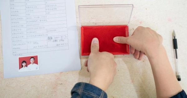 4月7日,在武汉市江岸区民政局婚姻登记处,新秀办理结婚手续时按手印。新华社记者 才扬/摄