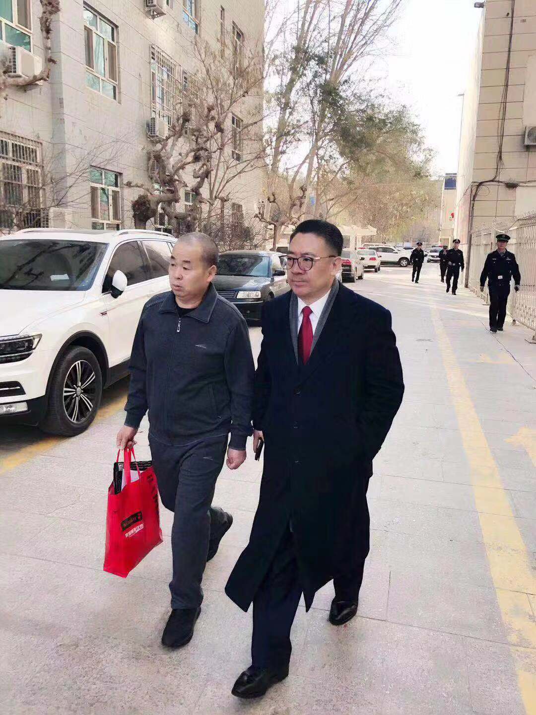 2019年12月3日,李建功(左)与律师王誓华从法院走出来。受访者供图