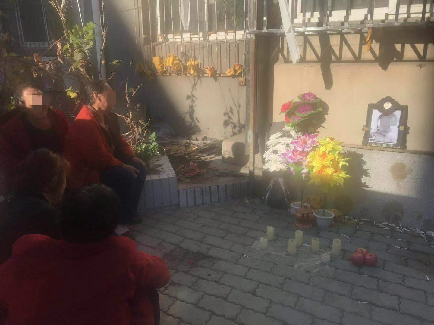 嫌疑人蔡某某的家门外，小琪的家属摆上了蜡烛与鲜花。新京报记者 王昱倩 摄