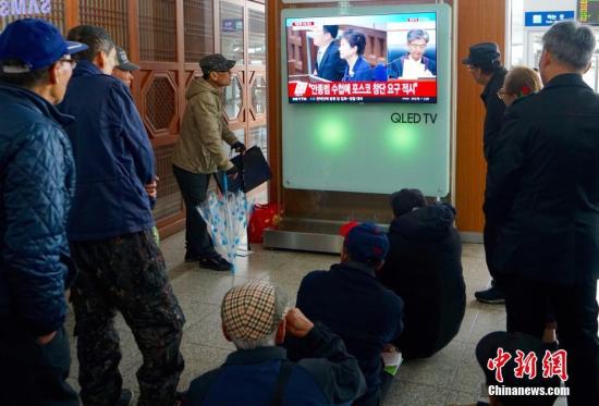 资料图：韩国首尔火车站，人们观看韩国前总统朴槿惠案宣判的直播画面。 中新社记者 吴旭 摄