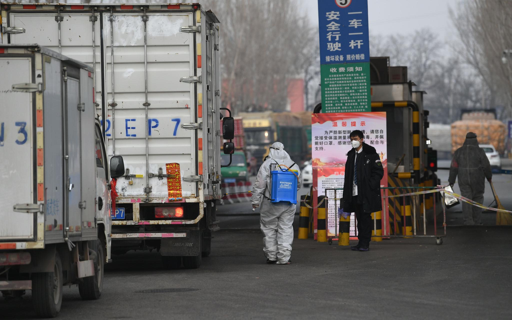 防疫人员在货车轮子上喷洒消毒液。新京报记者 王颖 摄
