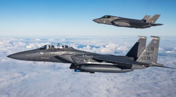 资料图片：美空军F-15E战斗轰炸机与英国空军F-35B隐身战机编队飞行。（图片来源于网络）