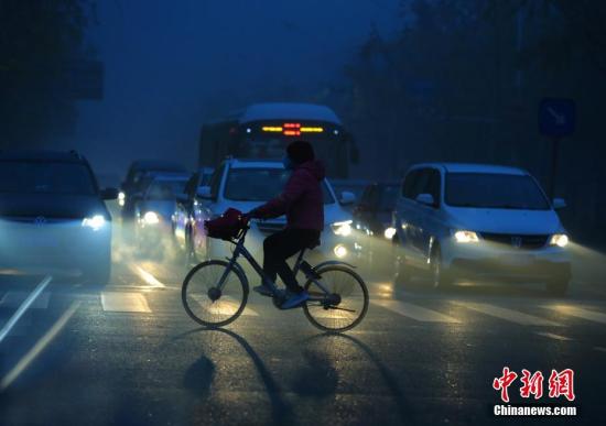 北京市民在重污染的大霧天氣中出行。中新社記者楊可佳攝