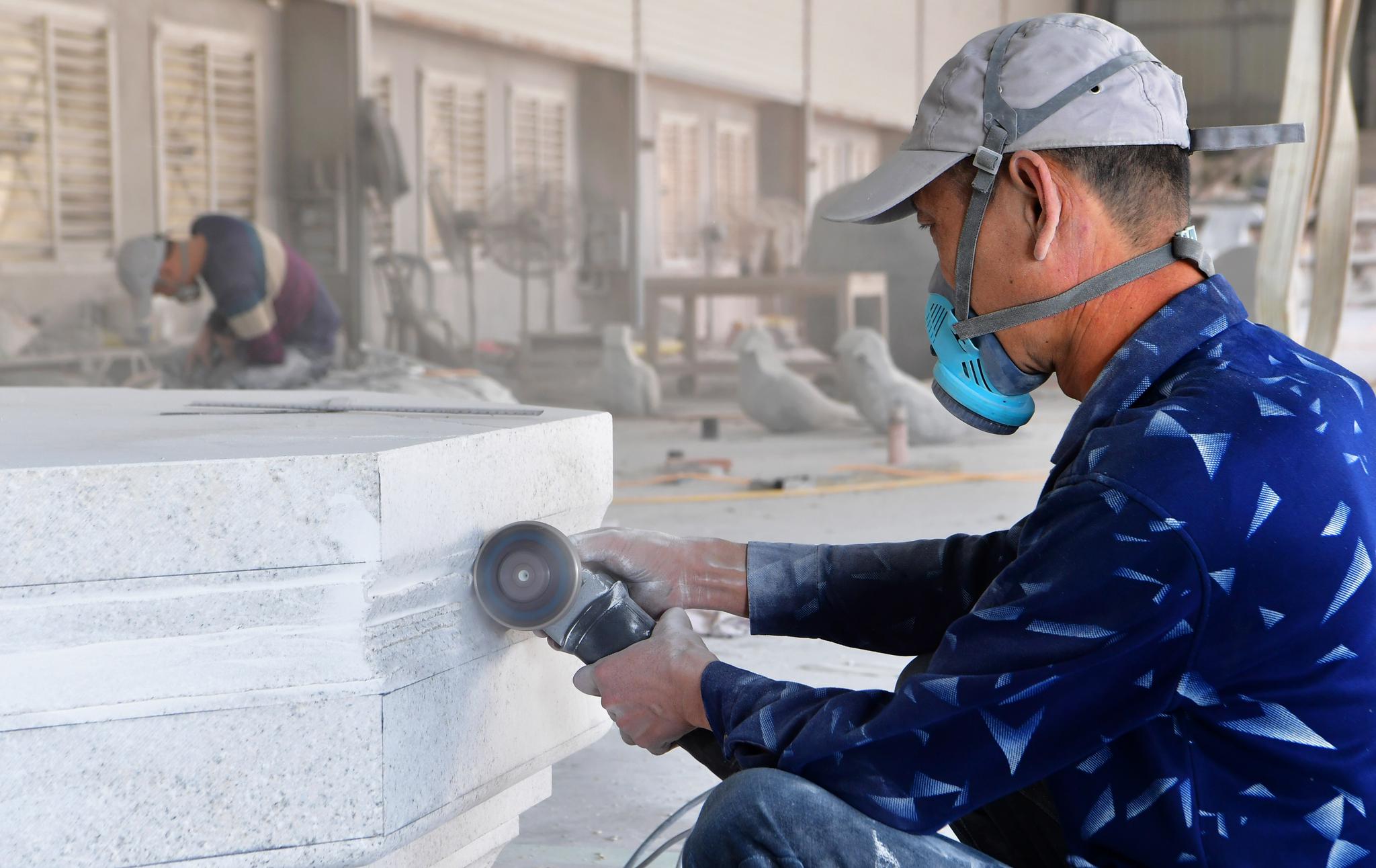 10月27日,一名工人正在打磨大型石雕的基座.