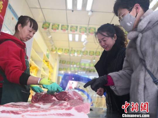  1月19日，记者走访农贸菜市场及猪肉专卖店，兰州市民选购猪肉。　史静静　摄