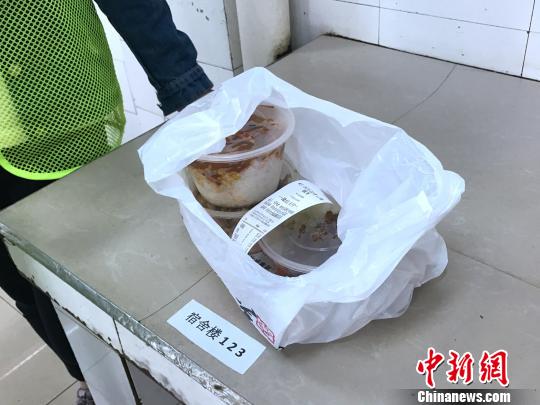 图为送餐的学生按宿舍地址分配餐品。　张一辰 摄