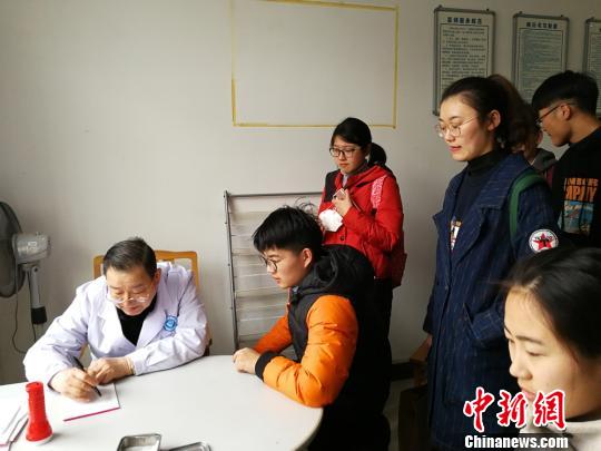 3月22日傍晚，依然有多位学生因为腹泻呕吐等症状在学校医务室排队就诊。　朱志庚 摄