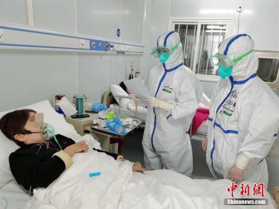 2月9日晚，武汉雷神山医院接收了第二批新冠肺炎患者。图为医护人员查房。 中新社发 高翔 摄