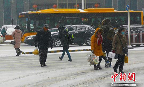 市民顶着雪前行。