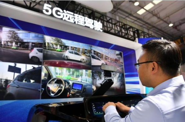 ▲工作人员展示5G远程驾驶。图片来自新京报。