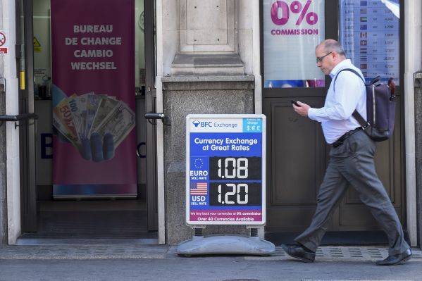 资料图片：英国伦敦，一名男士经过一处货币兑换点。（新华社发）