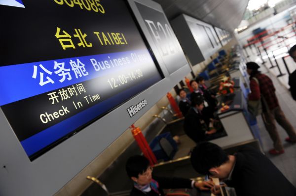 2008年12月26日,旅客在青岛流亭国际机场办理登机手续。当日,青岛至台湾空中客运直航正式开通。新华社记者李紫恒摄