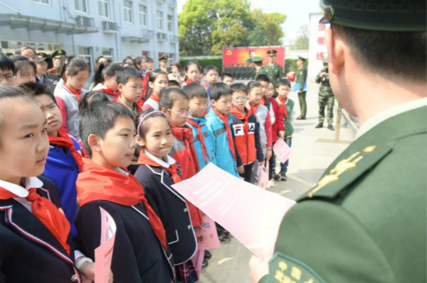 图说：孩子们听武警战士讲革命故事。陈乾根 刘威 摄（下同）