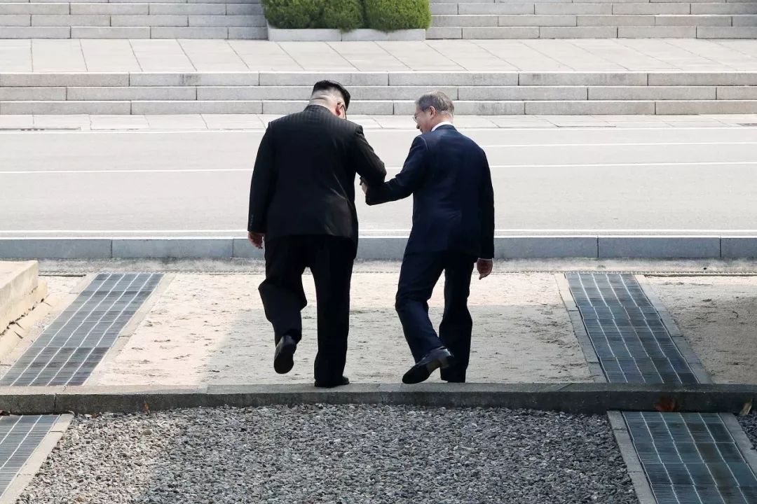 ▲当地时间2018年4月27日,韩国坡州,朝鲜最高领导人金正恩和韩国总统文在寅手牵手跨过军事分界线,进入板门店朝韩非军事区的北侧。(视觉中国)