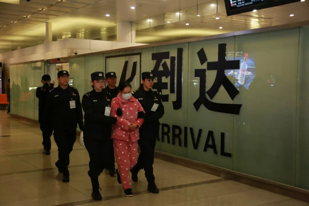 图为杭州警方将嫌疑人押解出萧山机场
