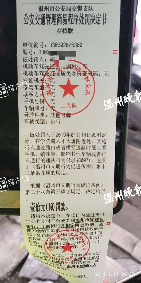 《温州市文明行为促进条例》今年元旦开始实施后，在斑马线上看手机被处罚的首张罚单。  温州晚报 资料图