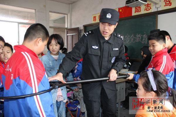 4月13日,在台州市椒江区东门小学,民警给学生讲解警用抓捕器的作用.