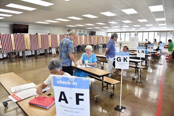 　图说：11月6日，在美国夏威夷州火奴鲁鲁一处投票站，工作人员核实选民的身份信息。新华社