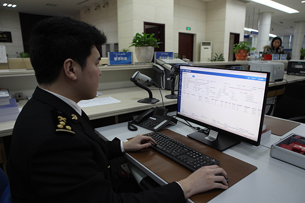 图为:宁波海关通关关员对出口汽车报关单开展接单审核   张佐/摄1月3