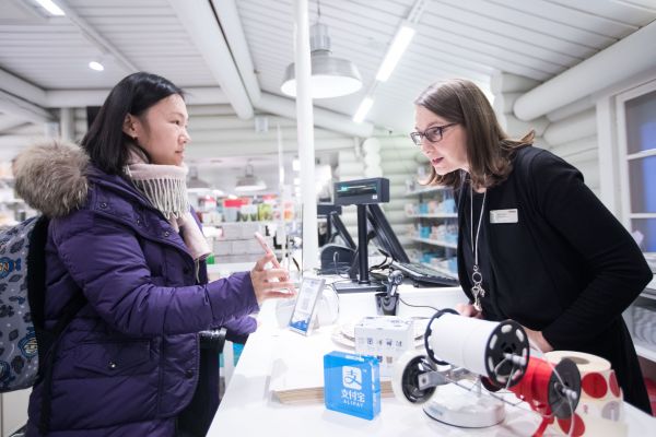 资料图片：中国游客在芬兰商店使用支付宝付款。（企业供图）