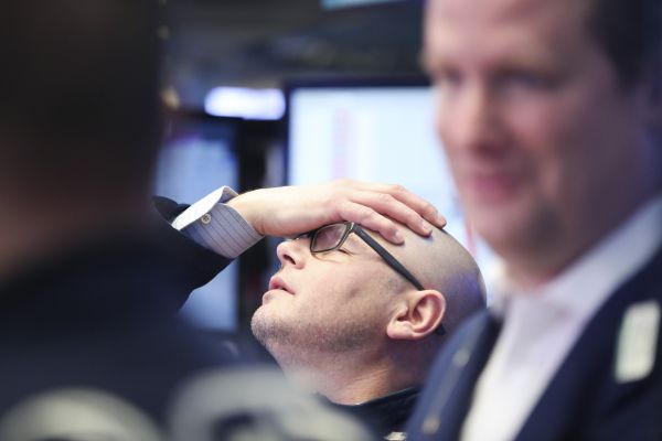 资料图：纽约证券交易所的一名交易员在股市收盘后小憩。