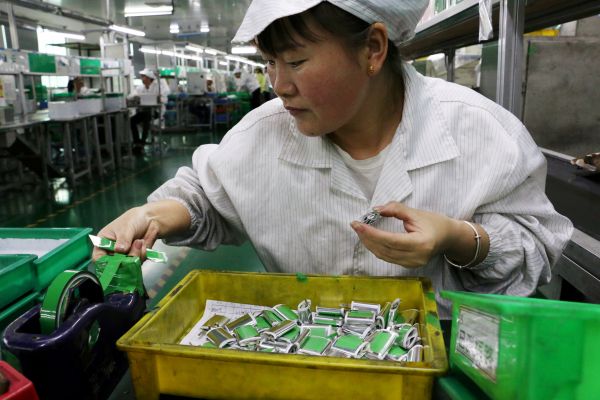 　　资料图片：广东东莞，一家锂电池工厂，一名员工在生产线上工作。（路透社）