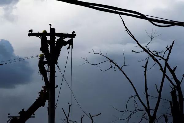▲资料图片：电力工人在菲律宾检修损坏的电线。（新华社）