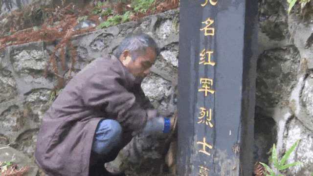  谢红军擦拭墓碑。秦浩摄