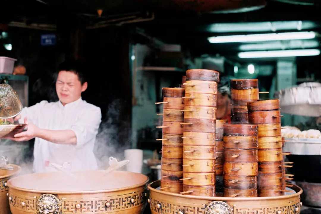 间的缝隙里洒下   将所有人镀上一层金色   人们坐在自家门前吃着早餐