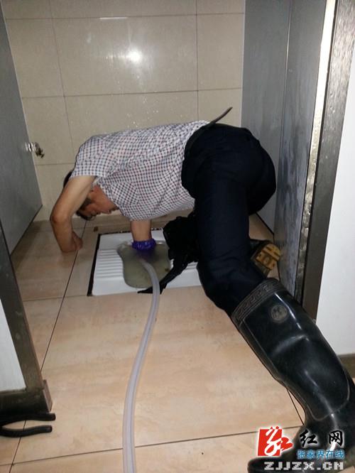 厕所保洁员代春齐正在疏通下水道红网张家界站8月15日讯(通讯员 黄丽