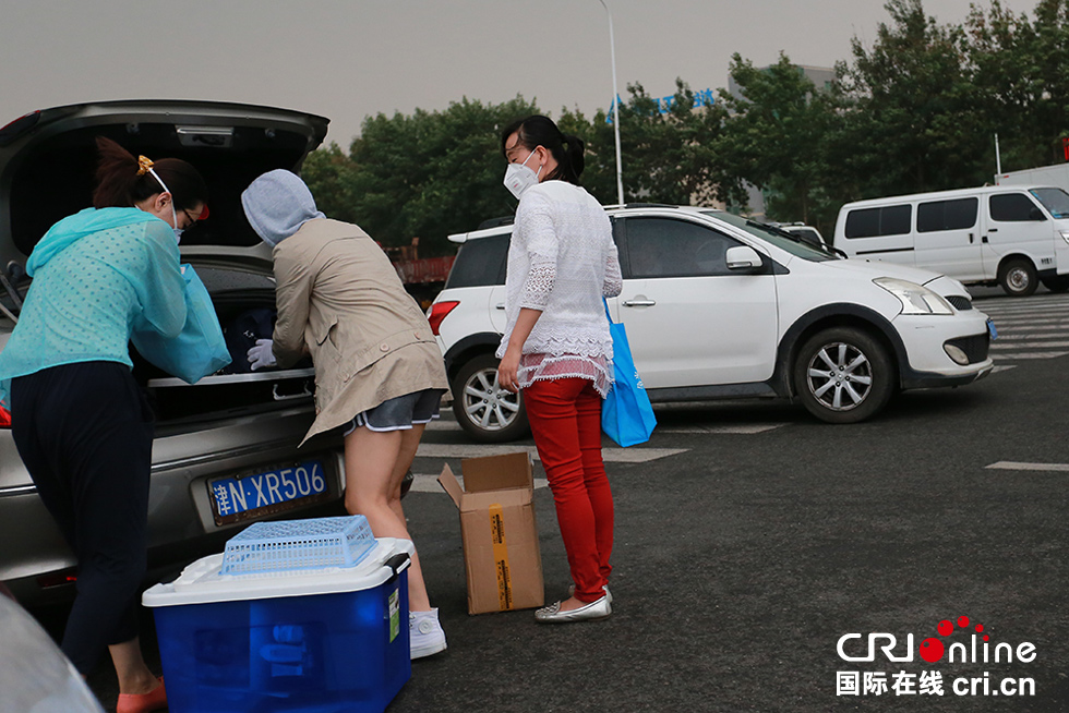 天津滨海新区出现降雨 市民冒雨回家拿行李(高清组图)