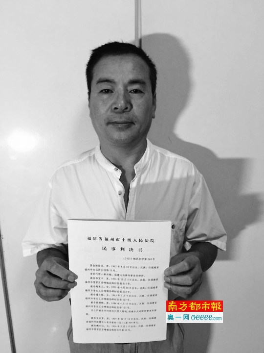 深圳警察设局杀人案 被诬陷而坐牢的陈信滔拿着福州市中院的重审判决书。受访者提供