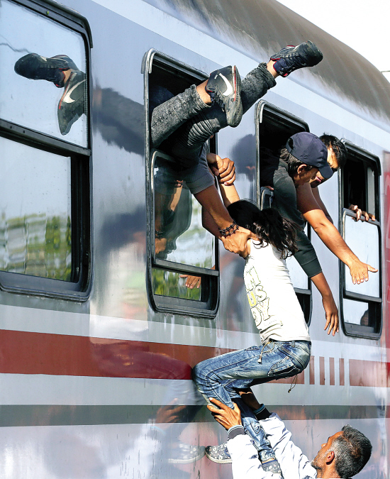 在克罗地亚一个火车站,难民争先恐后地爬上火车.cfp图