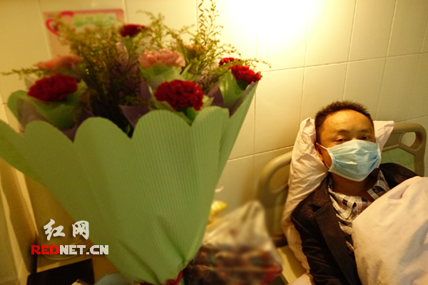 (病床上的龚福民,旁边放着学生送的花)