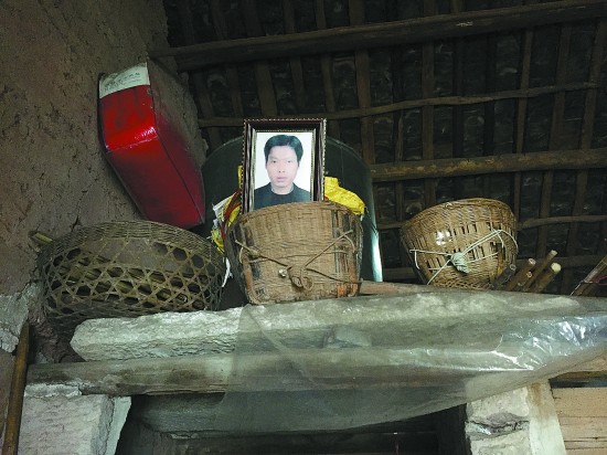 女子掐死家暴丈夫 周德军的遗像现在放在土屋里石仓上的一个箩筐里