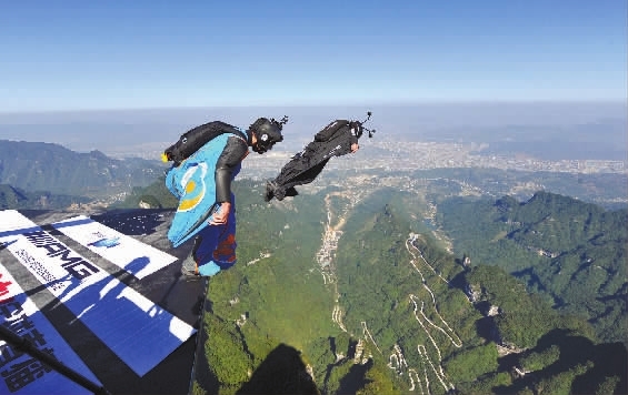 杰布(前一)从海拔1400余米的天门山山顶起跳.