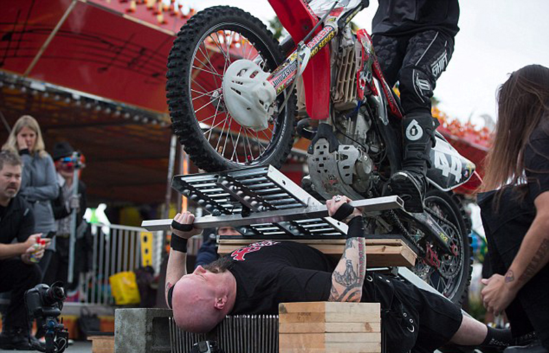 特技演员躺钉床被70辆摩托车辗过 刷新世界纪录(组图)