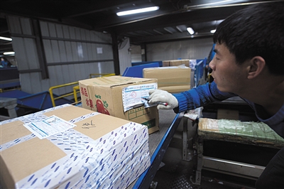 运送快件的货车到达后,工作人员迅速将货物搬上传送带.