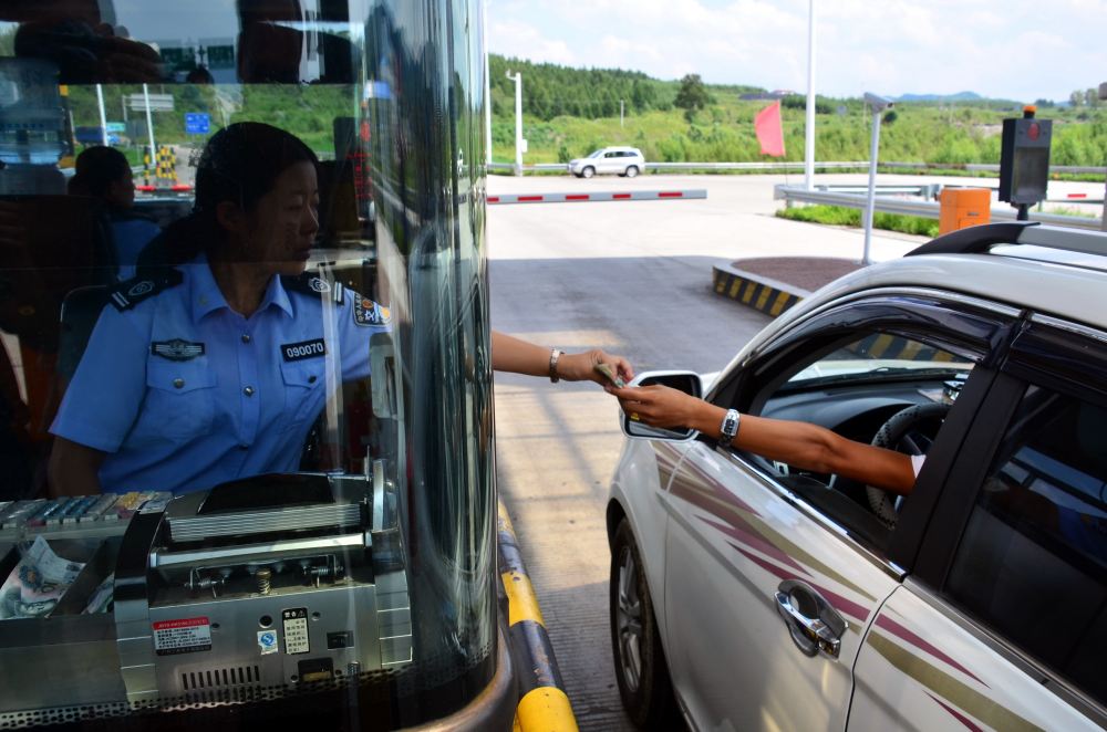 黑龍江雞西高速公路管理處興農收費站收費員正在對車輛收費.