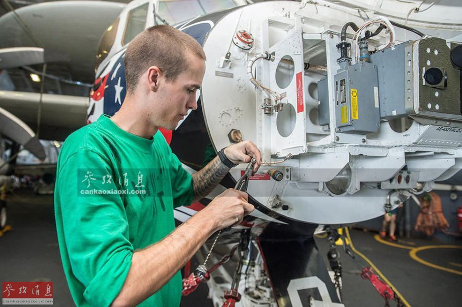 一群维修技师正在对e-2c预警机的涡桨发动机进行维修和保养