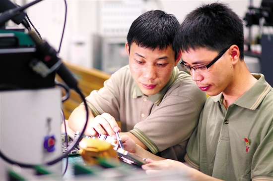 李天明(左一)与徒弟陈坤日常工作照.