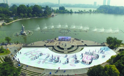 在玄武湖莲花广场上,一幅由众多青年志愿者手绘的巨幅扇形画"我爱玄武