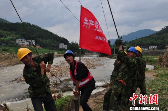 图为在永泰县清凉镇10千伏岭下线63号杆,电杆被洪水冲毁,武平供电支援