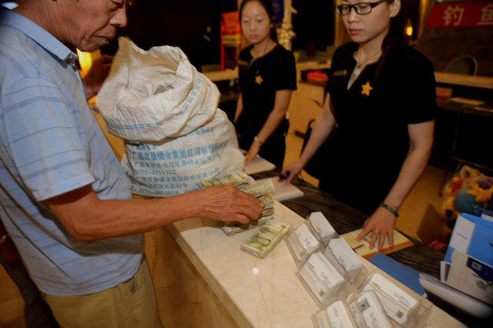 老人扛一整袋零钱买房售楼处铺满纸币