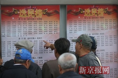 社区居民将选民榜放入宣传橱窗.