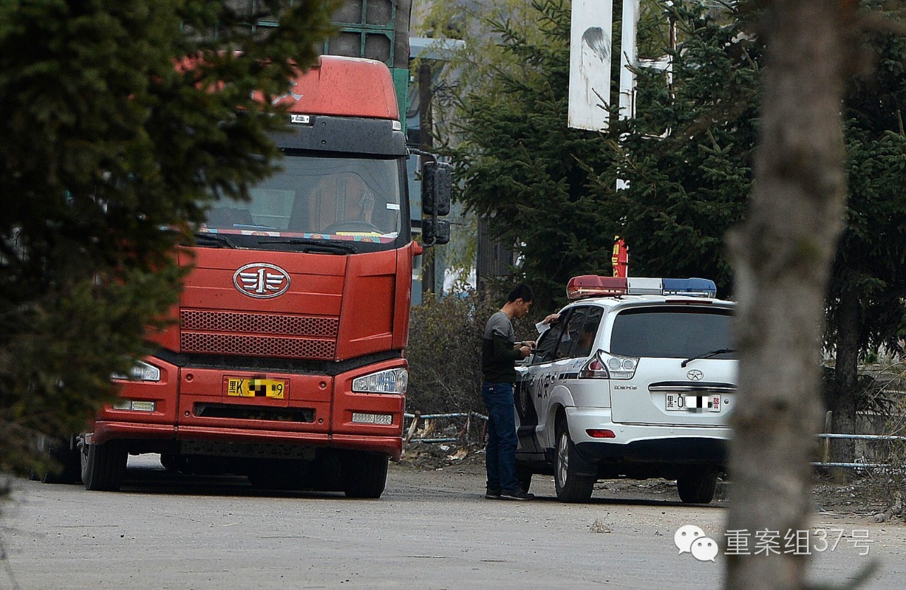 一辆货车司机下车后将一个纸条递进警车,交警看过后返还给货车司机.