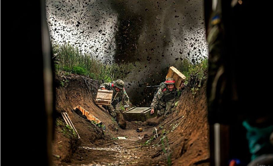 在掩体中作战的乌军机枪手,可见满装的弹药箱.