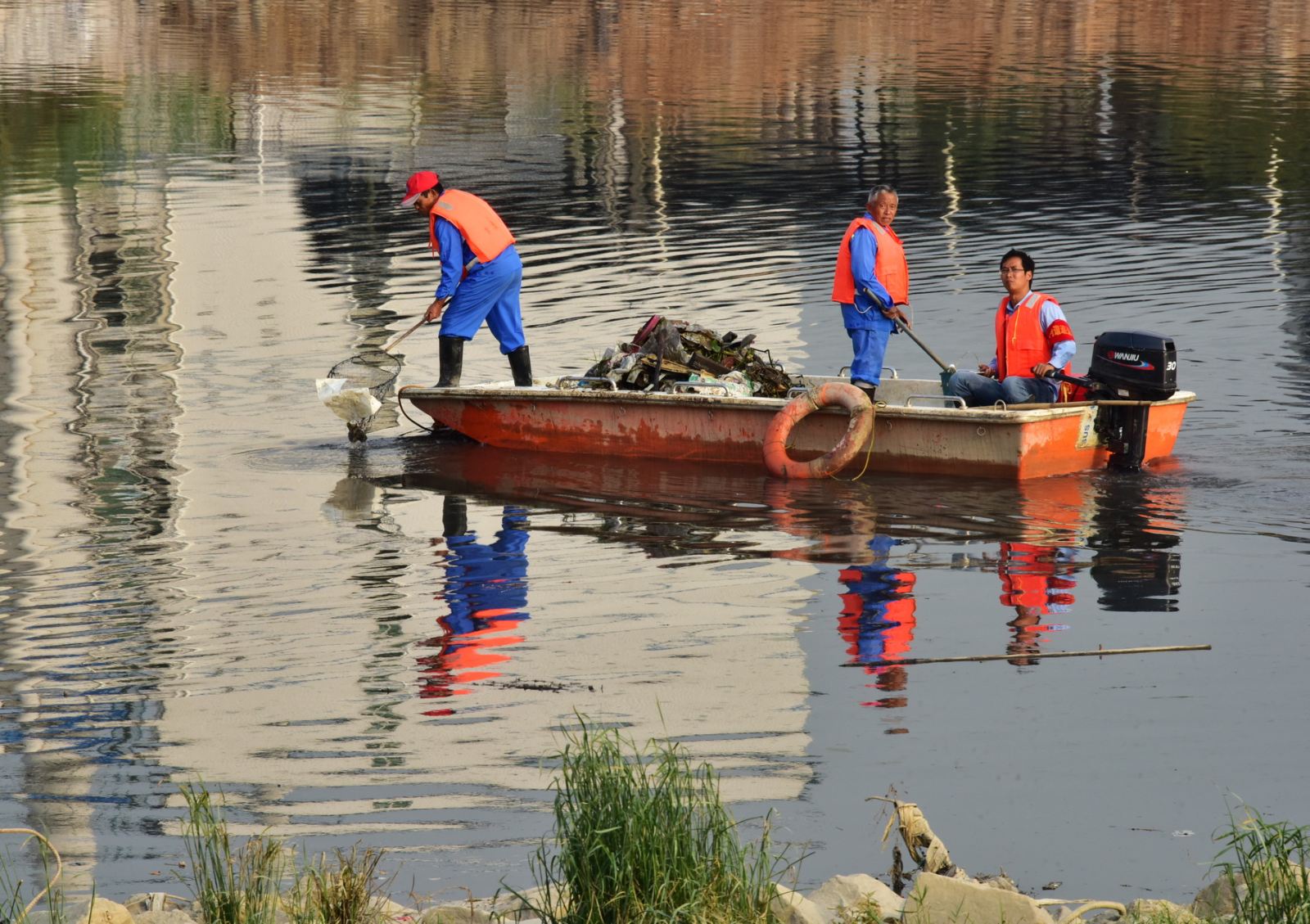 保洁员每天下河打捞垃圾,这在全国许多地方已经司空见惯.摄影/章轲