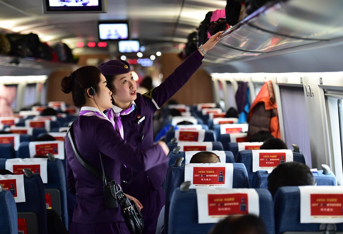 1月12日,列车员在北京南开往合肥南的列车上整理行李架.